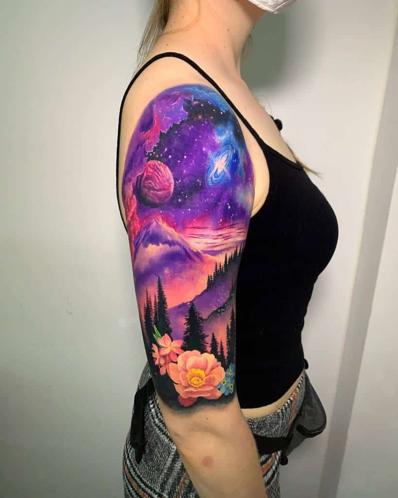 Woman with colorful space-themed tattoo sleeve featuring planets, mountains, and flowers