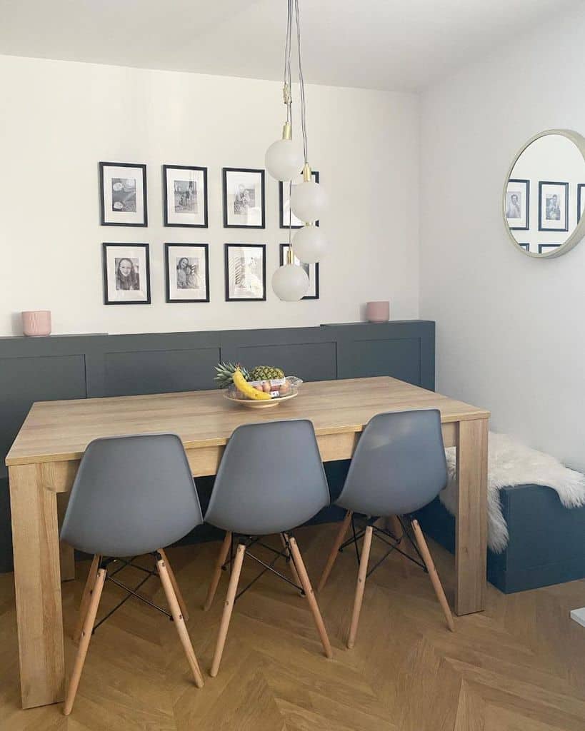 wood table gray chairs framed wall photos round pendant ceiling lights