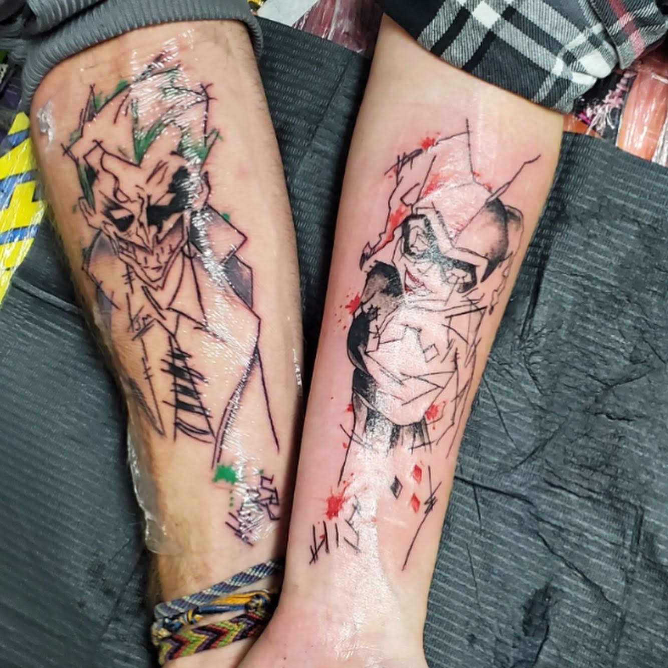 Stylized matching tattoos of the Joker and Harley Quinn with abstract, sketch-like designs
