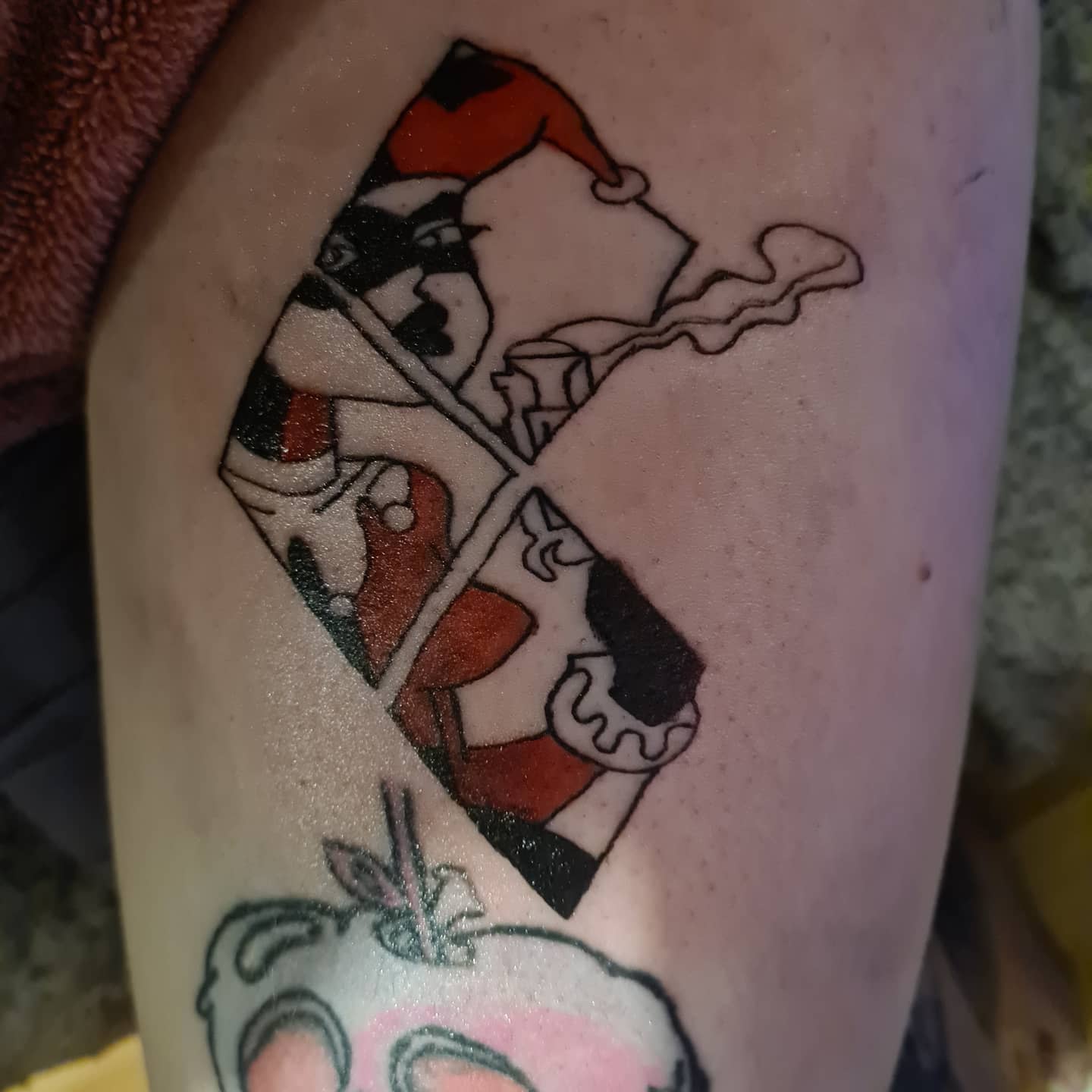 Forearm tattoo featuring a red and black argyle pattern with sketchy black accents