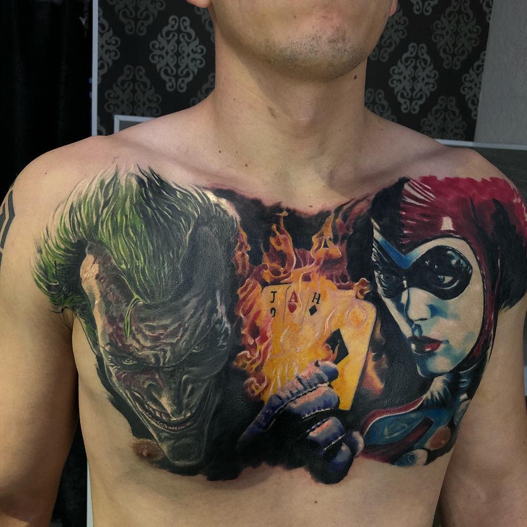 Chest tattoos featuring the Joker and Harley Quinn, separated by a flaming Joker card