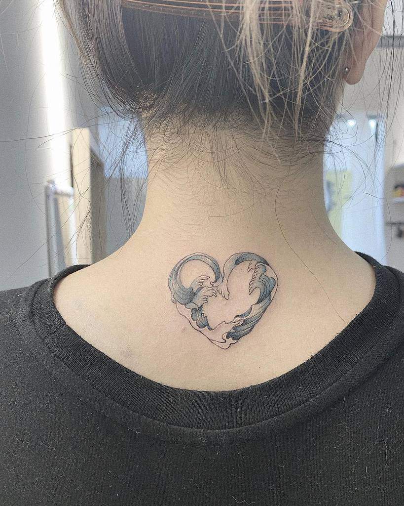 Tattoo of a heart-shaped dragon on the back of the neck, below a blonde hair bun