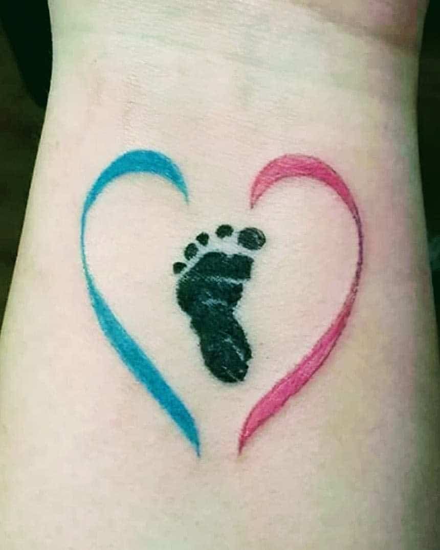 A tattoo of a baby's footprint inside a heart outline with the left side in blue and the right side in pink