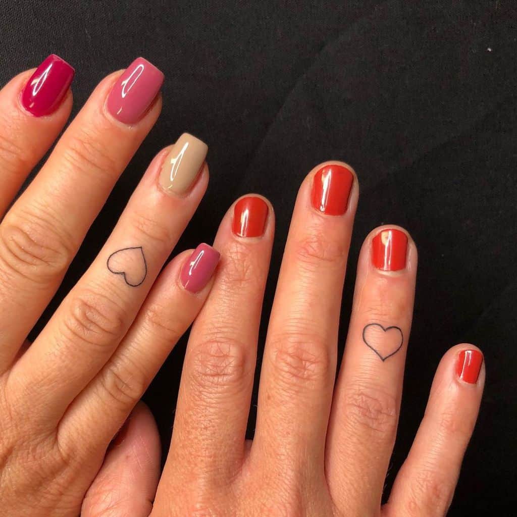 Small heart outline tattoos on the ring fingers