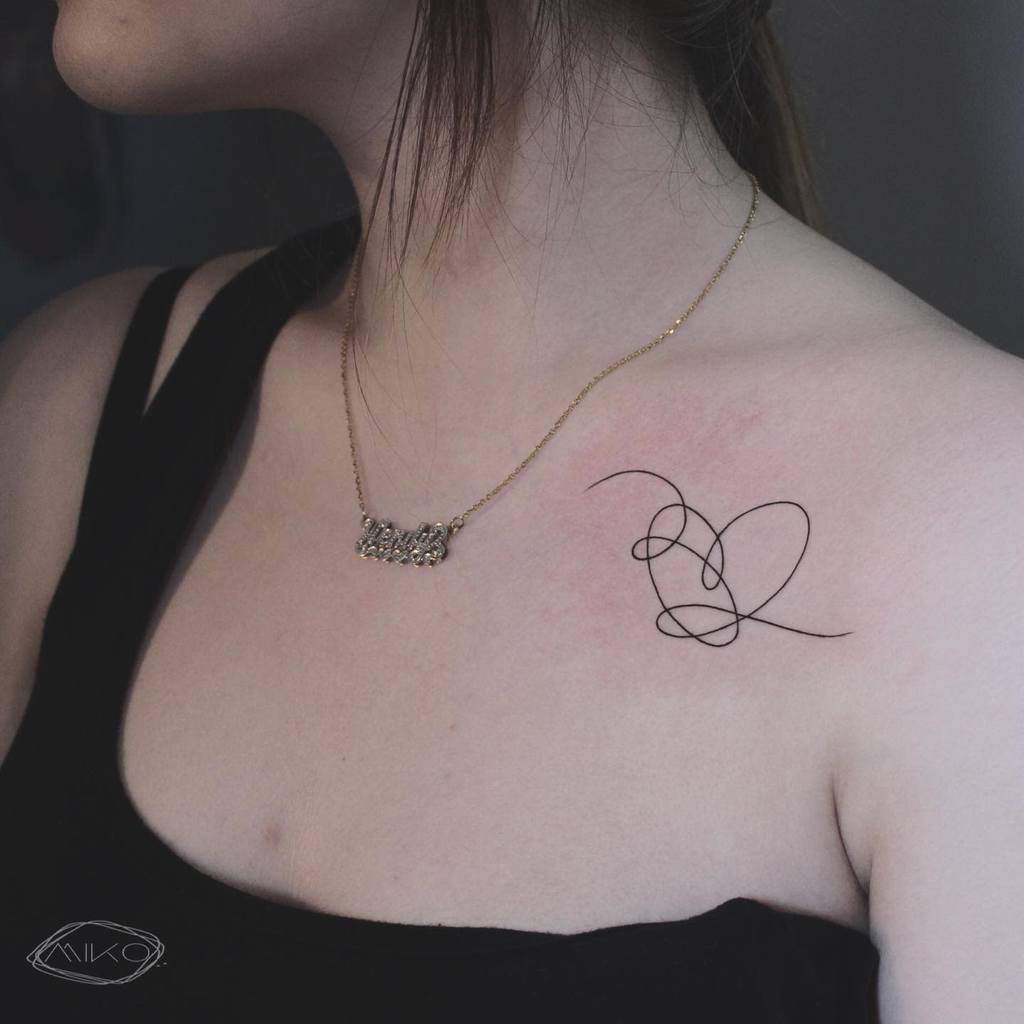 Tattoo of abstract heart-shaped lines on woman's shoulder