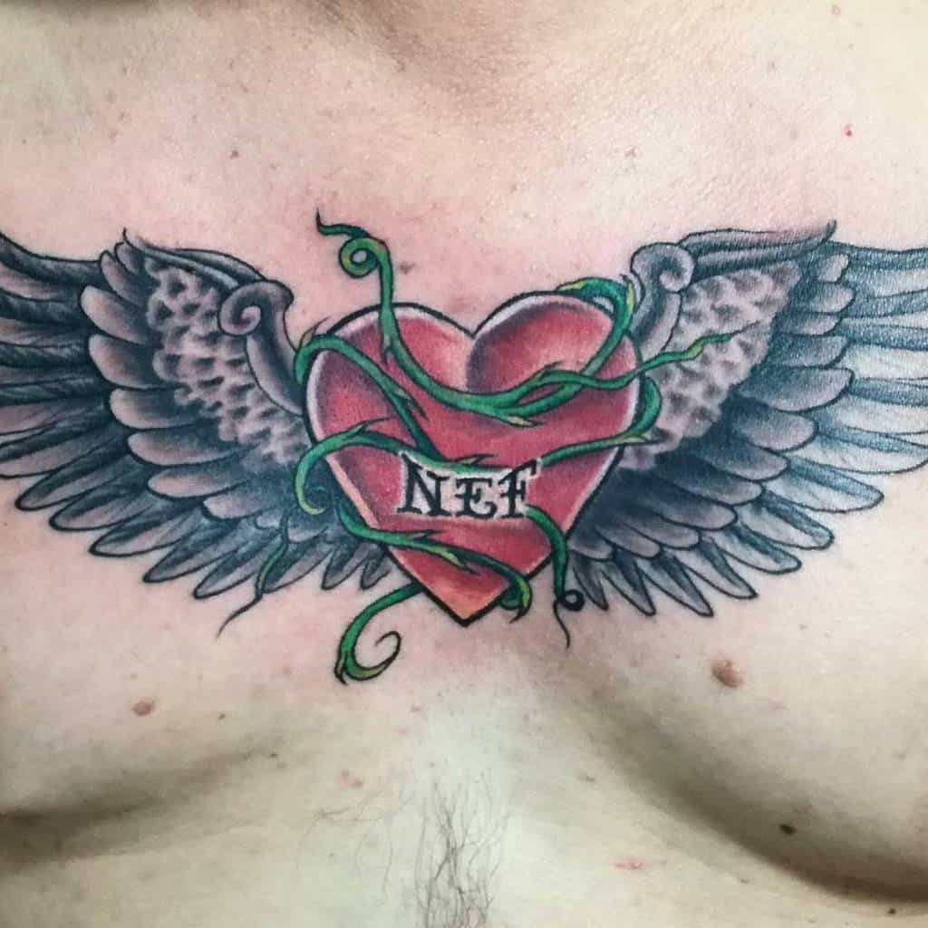 A heart tattoo with wings and green vines, featuring the text "NET" in the center—radiating love and freedom