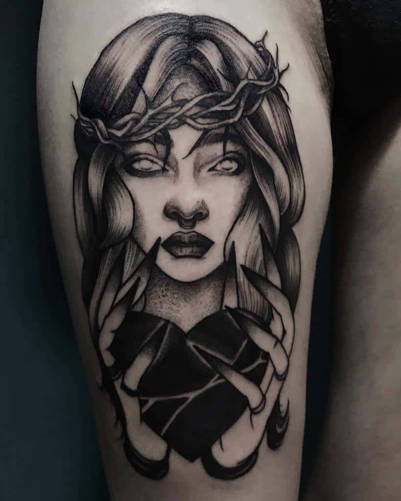 Dark gothic tattoo of a woman with a crown of thorns, glowing eyes, and sharp nails holding a cracked black heart