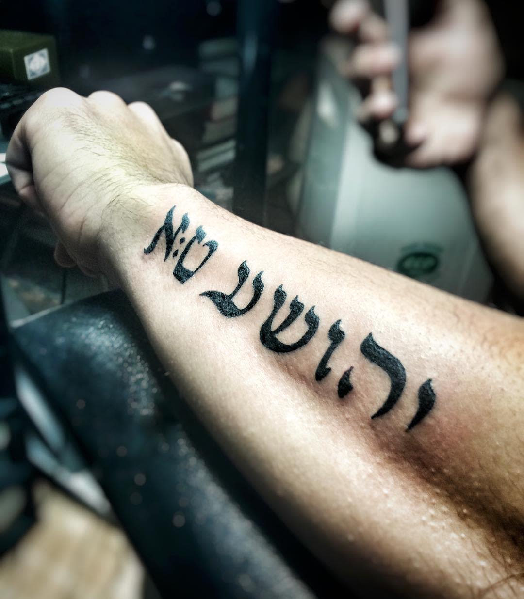 A forearm with a tattoo in Hebrew letters