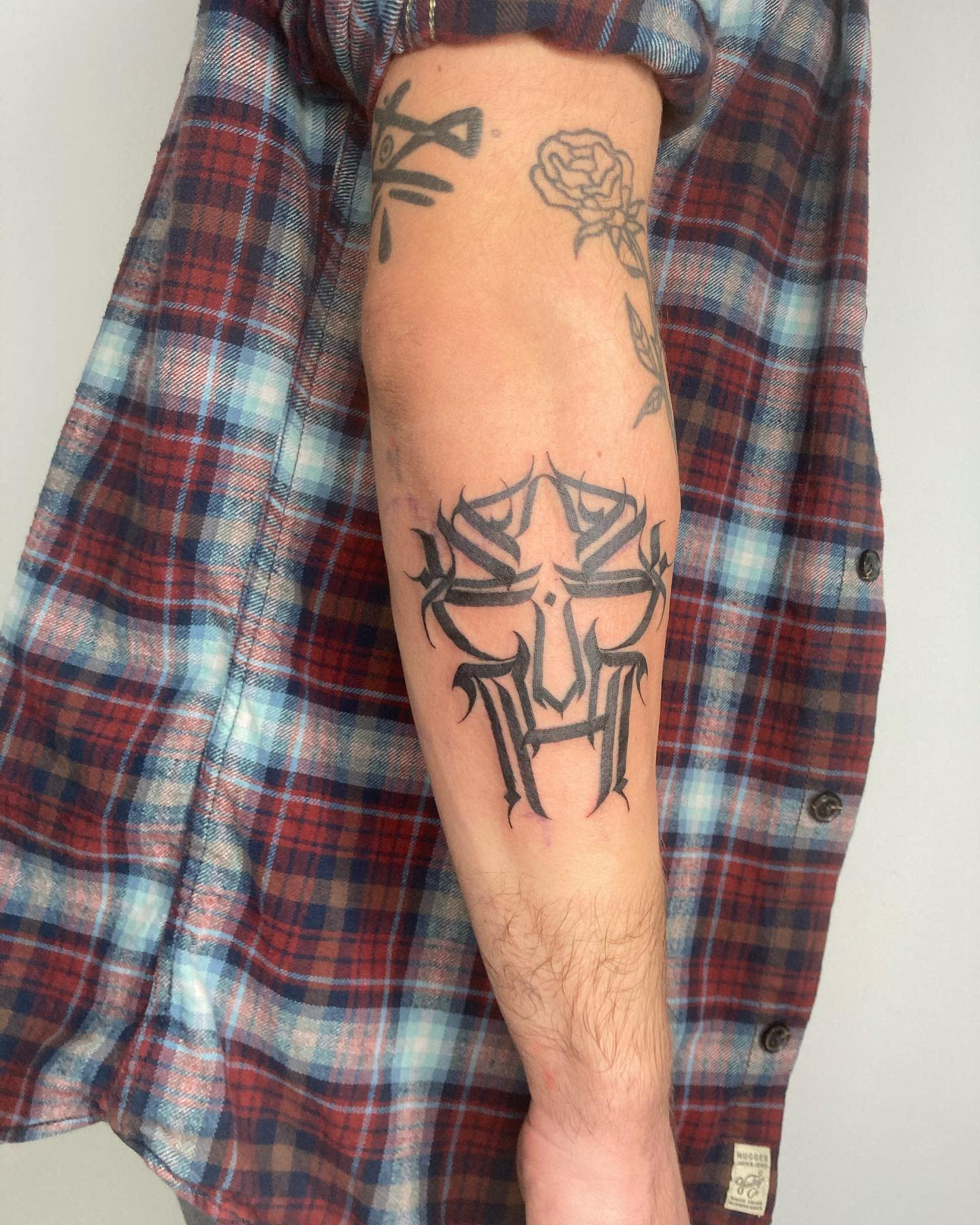 Arm with tribal-style tattoo in black ink