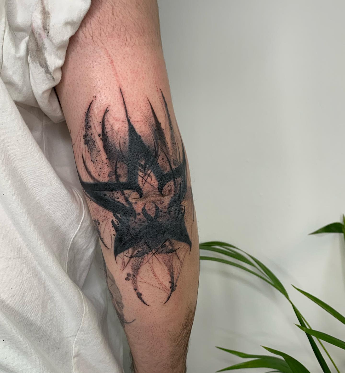 Arm with an abstract star black ink tattoo design