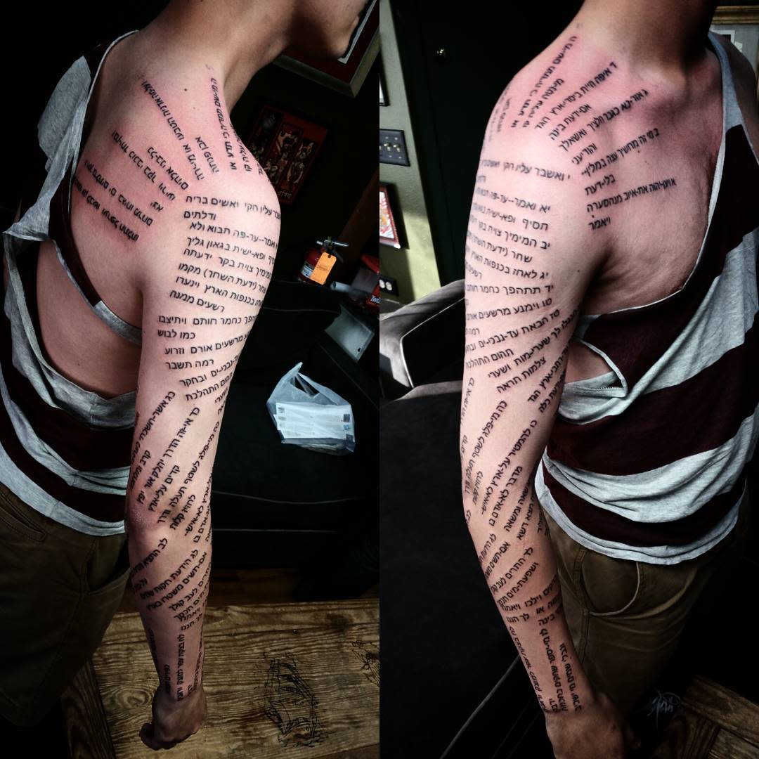 Individual with Hebrew text tattoos covering their left arm and shoulder