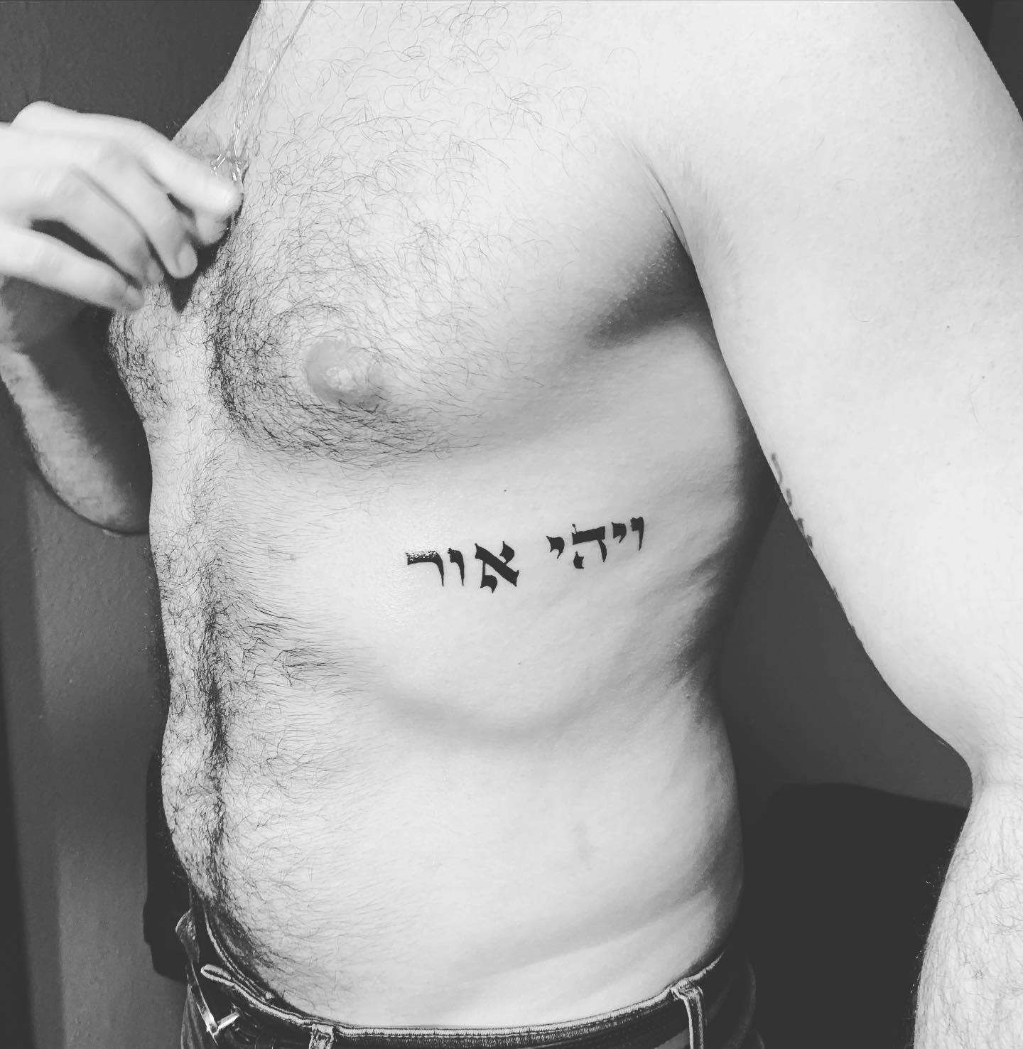 Individual with a Hebrew tattoo on their side