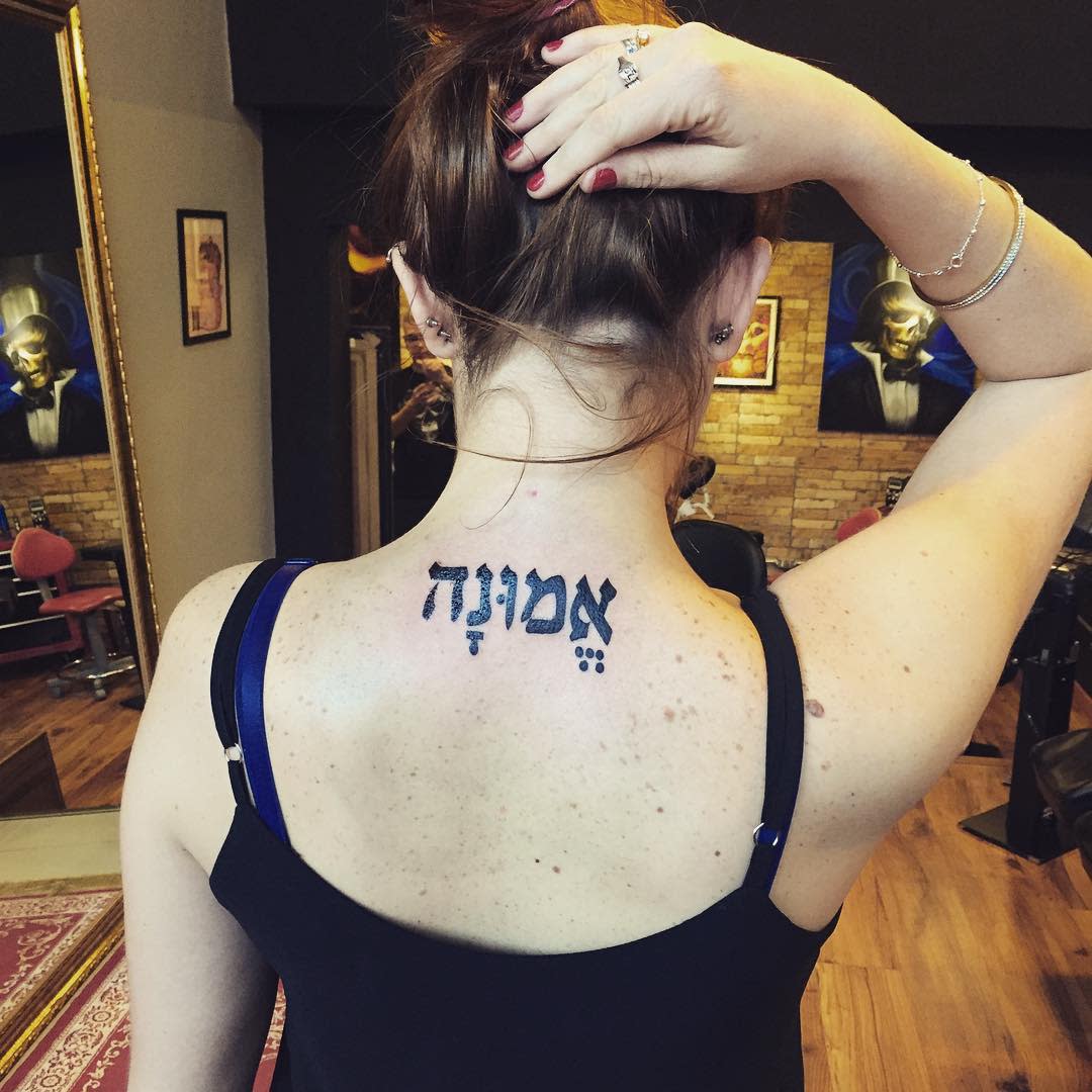 Woman with Hebrew tattoo on upper back