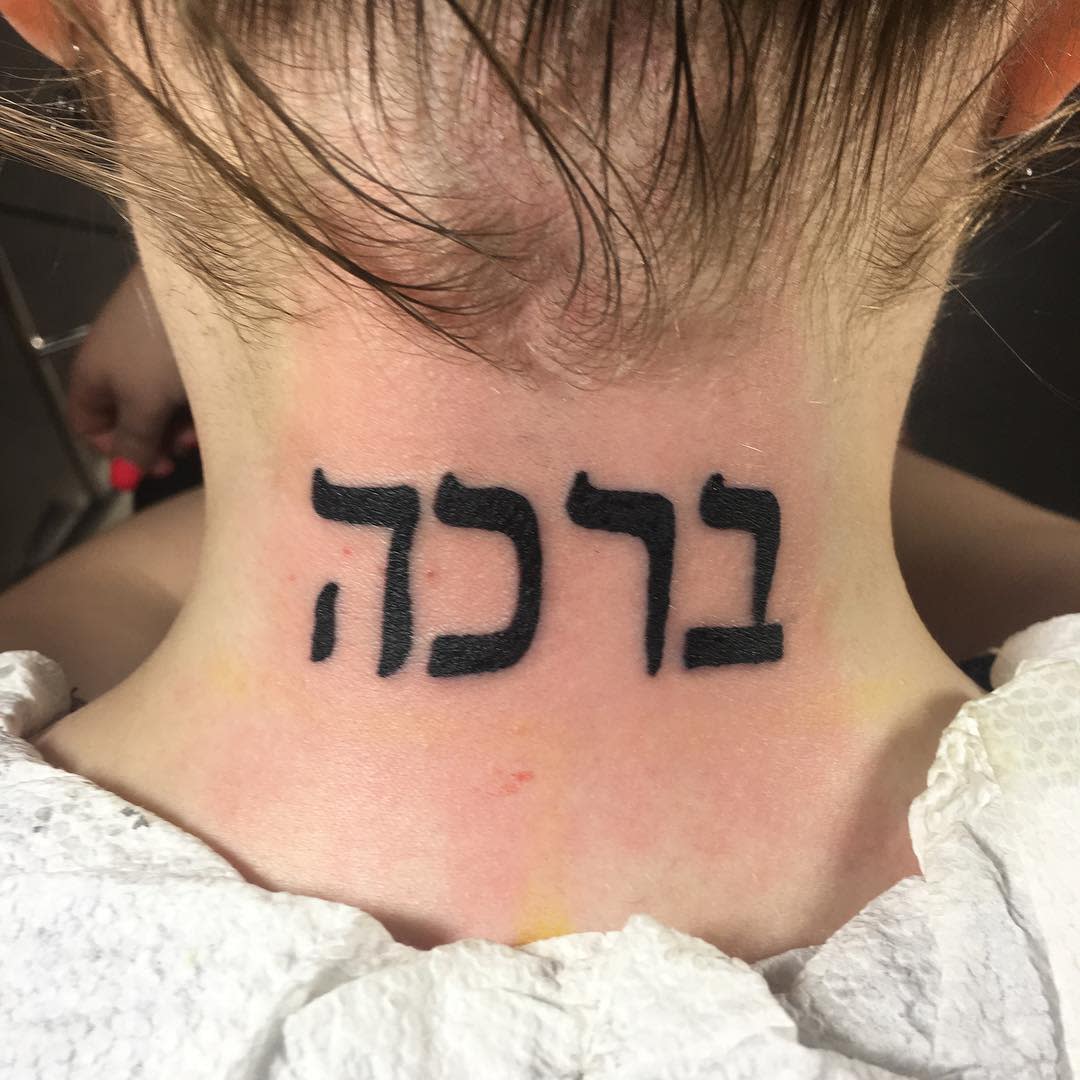 Tattoo of Hebrew letters on the back of a neck