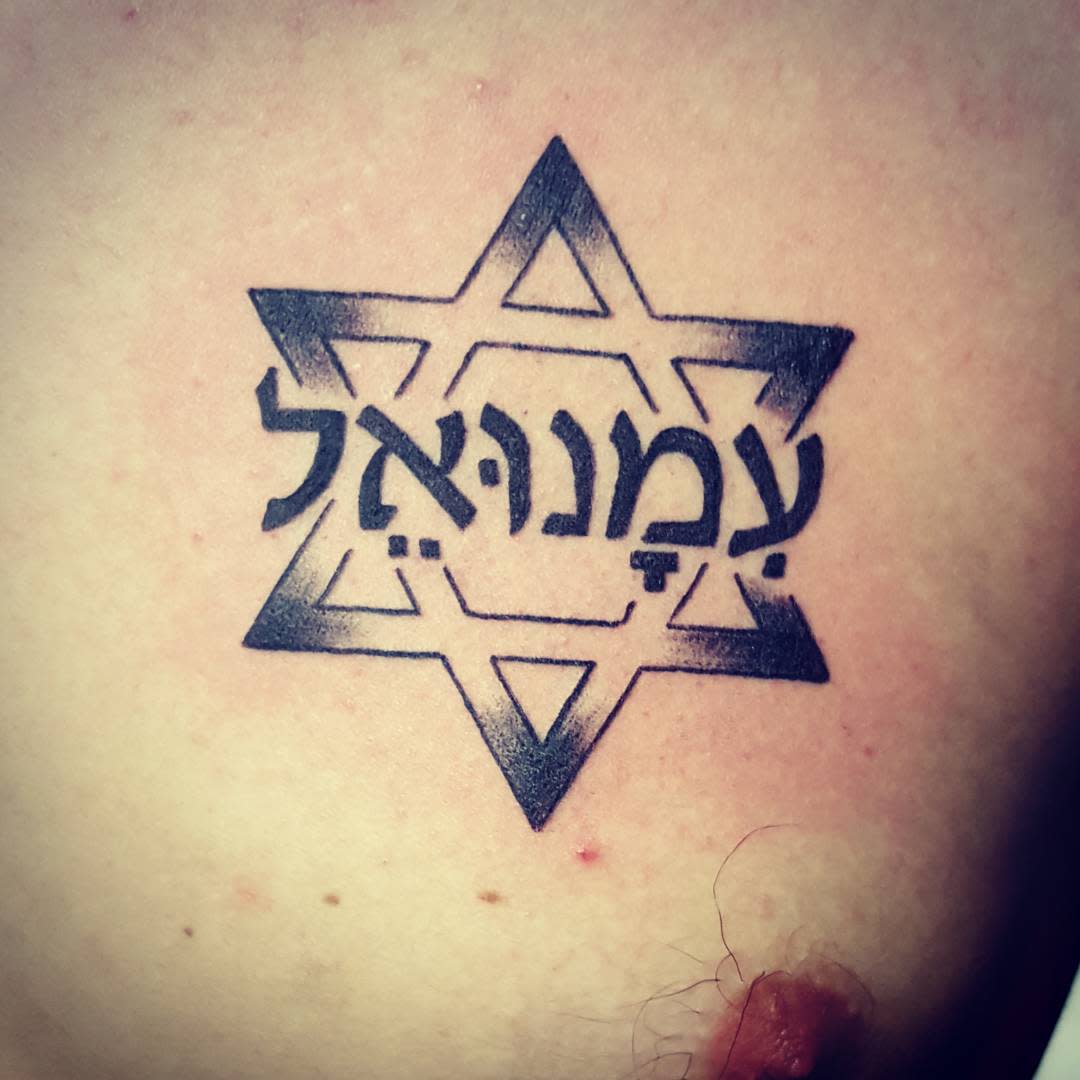 A tattoo of the Star of David with Hebrew text on skin