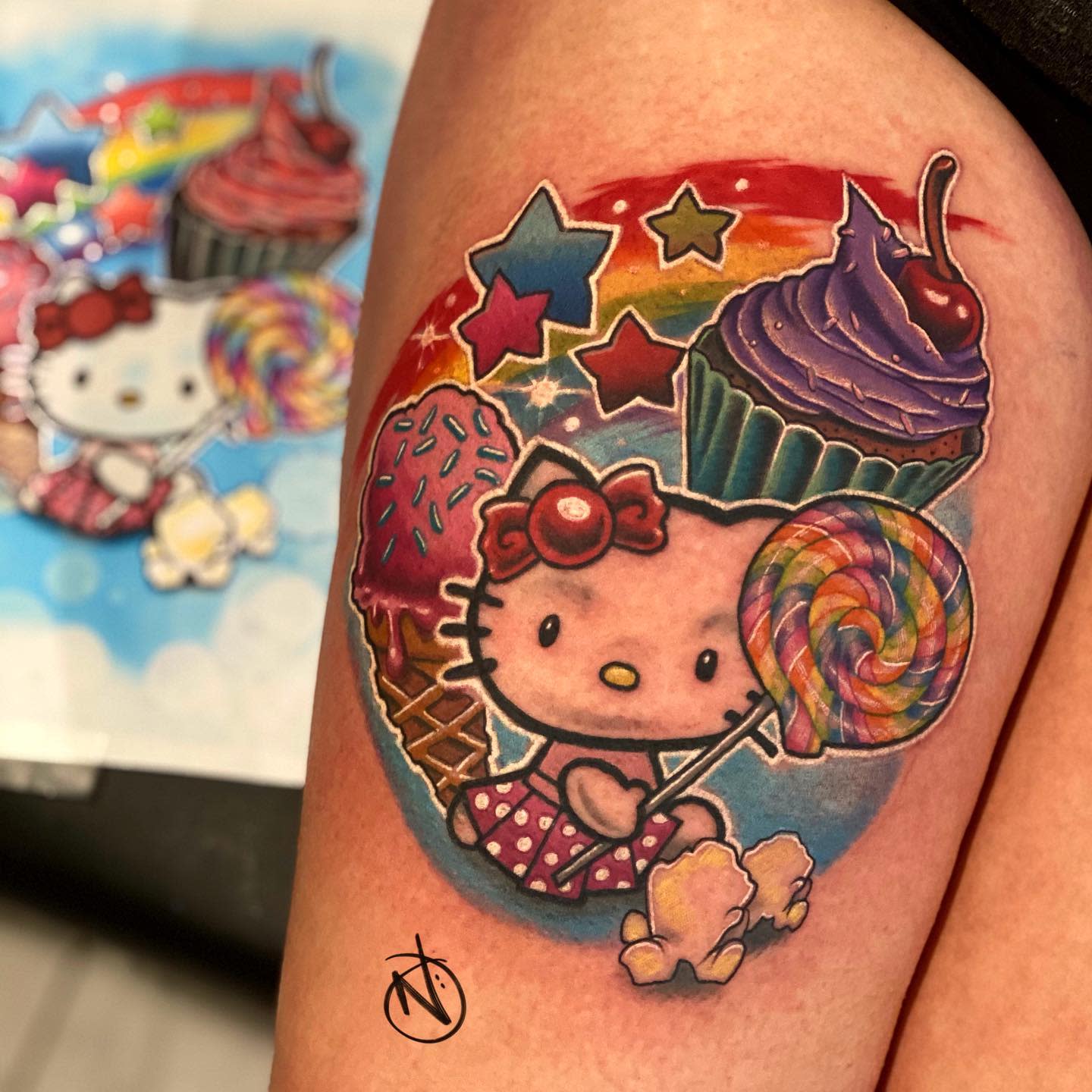Colorful tattoo of Hello Kitty with sweets, a rainbow, and stars on a vibrant background