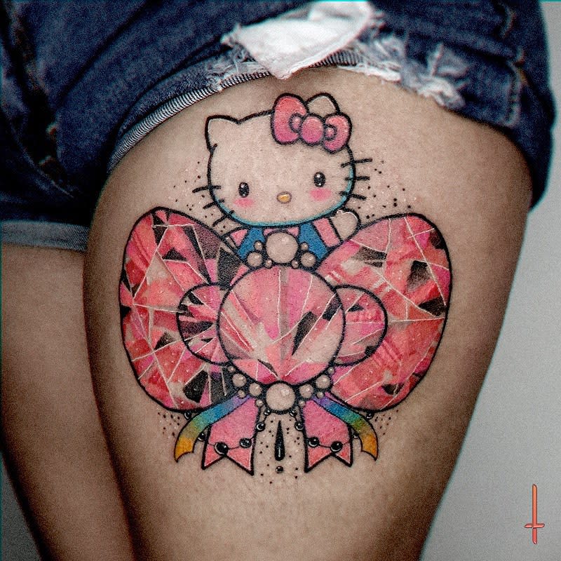 Hello Kitty tattoo with a large pink bow on a thigh