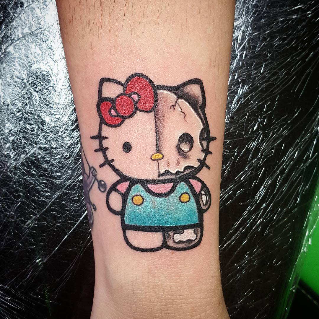 Tattoo of Hello Kitty half normal, half zombie, on an arm