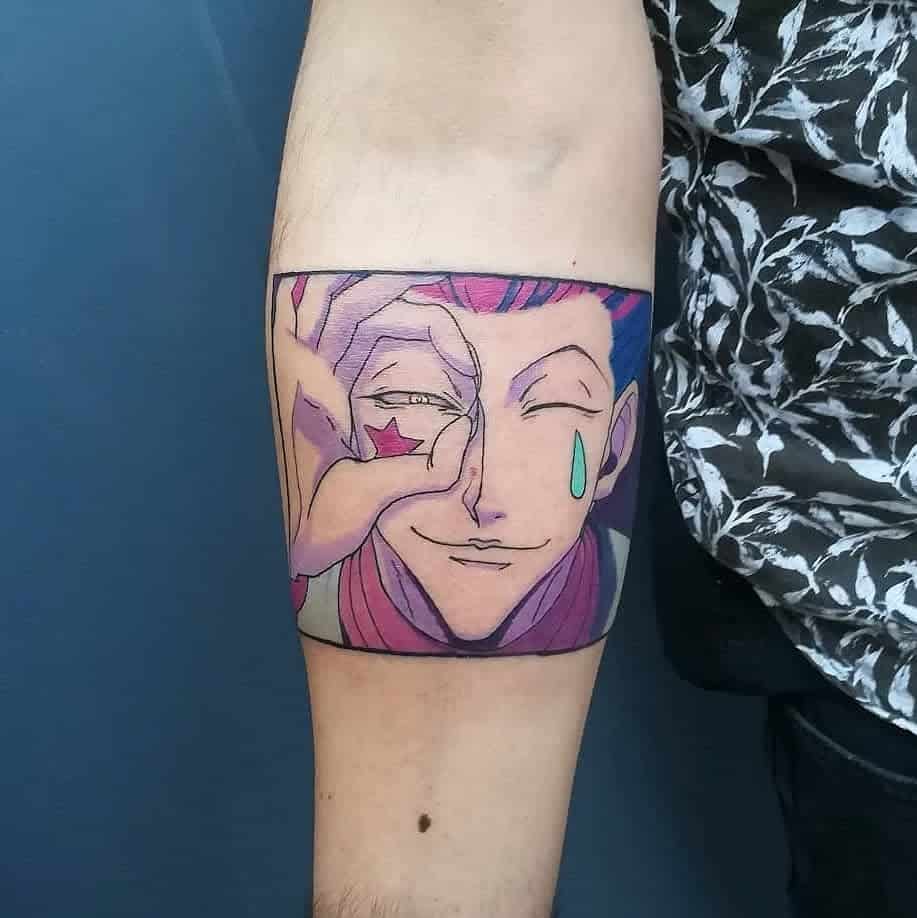 Vibrant tattoo of Hisoka Morow from Hunter x Hunter, showcasing his iconic playful expression with colorful details like the star and tear under his eyes