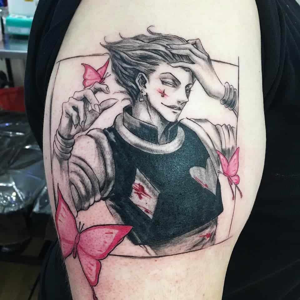 Detailed tattoo of Hisoka Morow from Hunter X Hunter, featuring pink butterflies and a sharp black-and-white portrait design