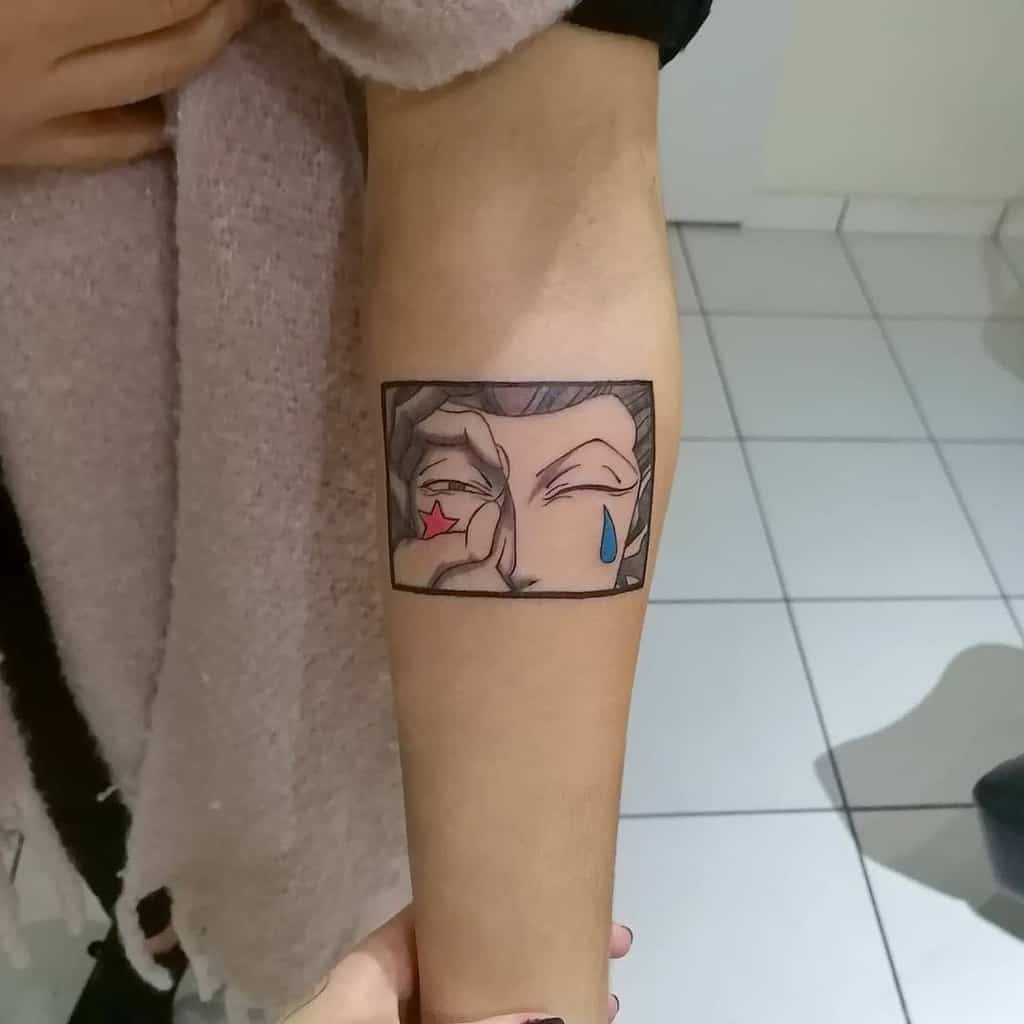 Unique tattoo of Hisoka Morow's close-up from Hunter X Hunter, highlighting his star, tear marks, and mischievous expression