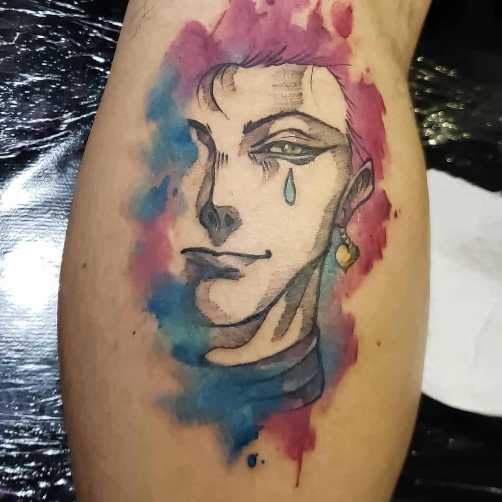 Watercolor-style tattoo of Hisoka Morow from Hunter X Hunter, featuring vibrant pink and blue splashes and his iconic tear mark