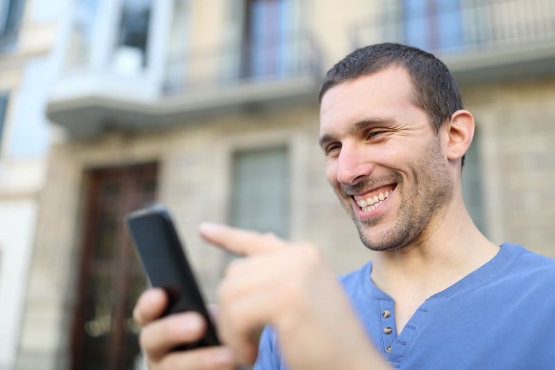 Happy,Adult,Man,Browsing,Mobile,Phone,Content,Walking,In,The