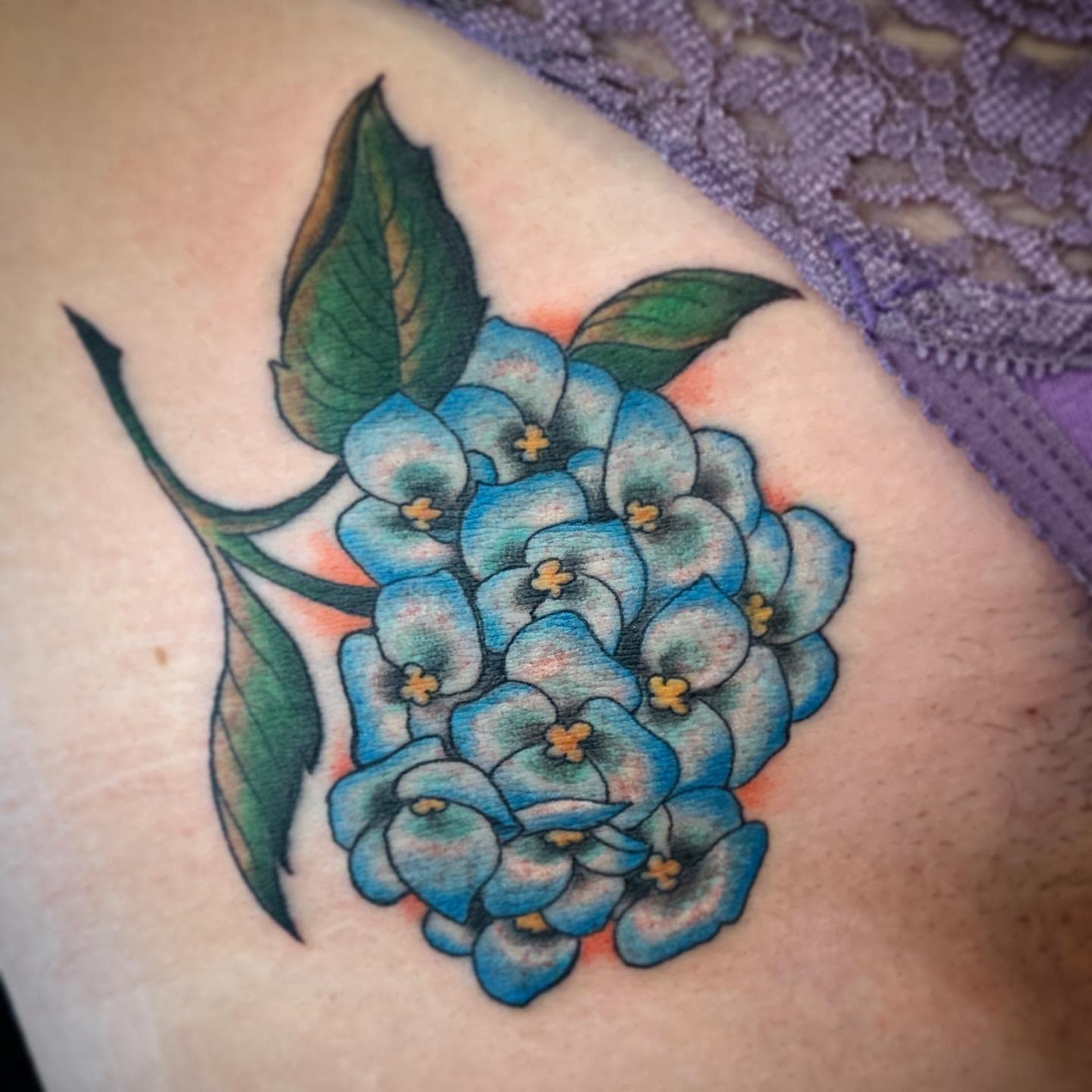 Blue hydrangea tattoo with green leaves