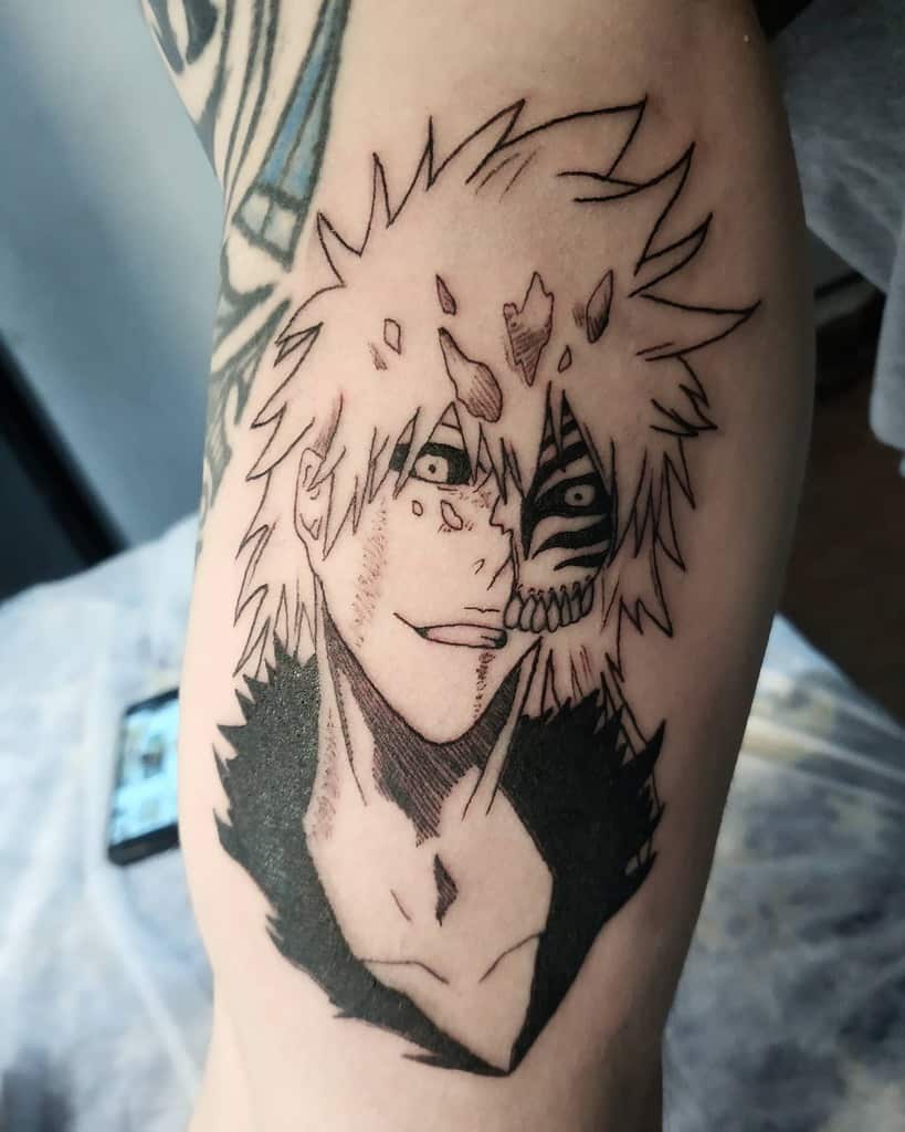 Black ink tattoo of Ichigo Kurosaki from Bleach, featuring his half-Hollow transformation with sharp mask details and intense expression