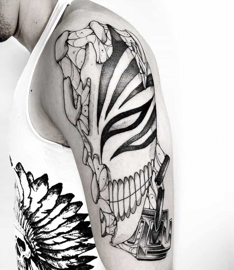 Black and grey tattoo of Ichigo Kurosaki’s Hollow mask from Bleach, featuring cracked fragments and bold shading 