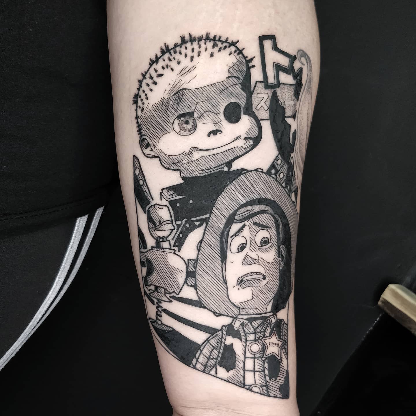 Arm tattoo of a boy doll and a cowboy doll from an animated movie