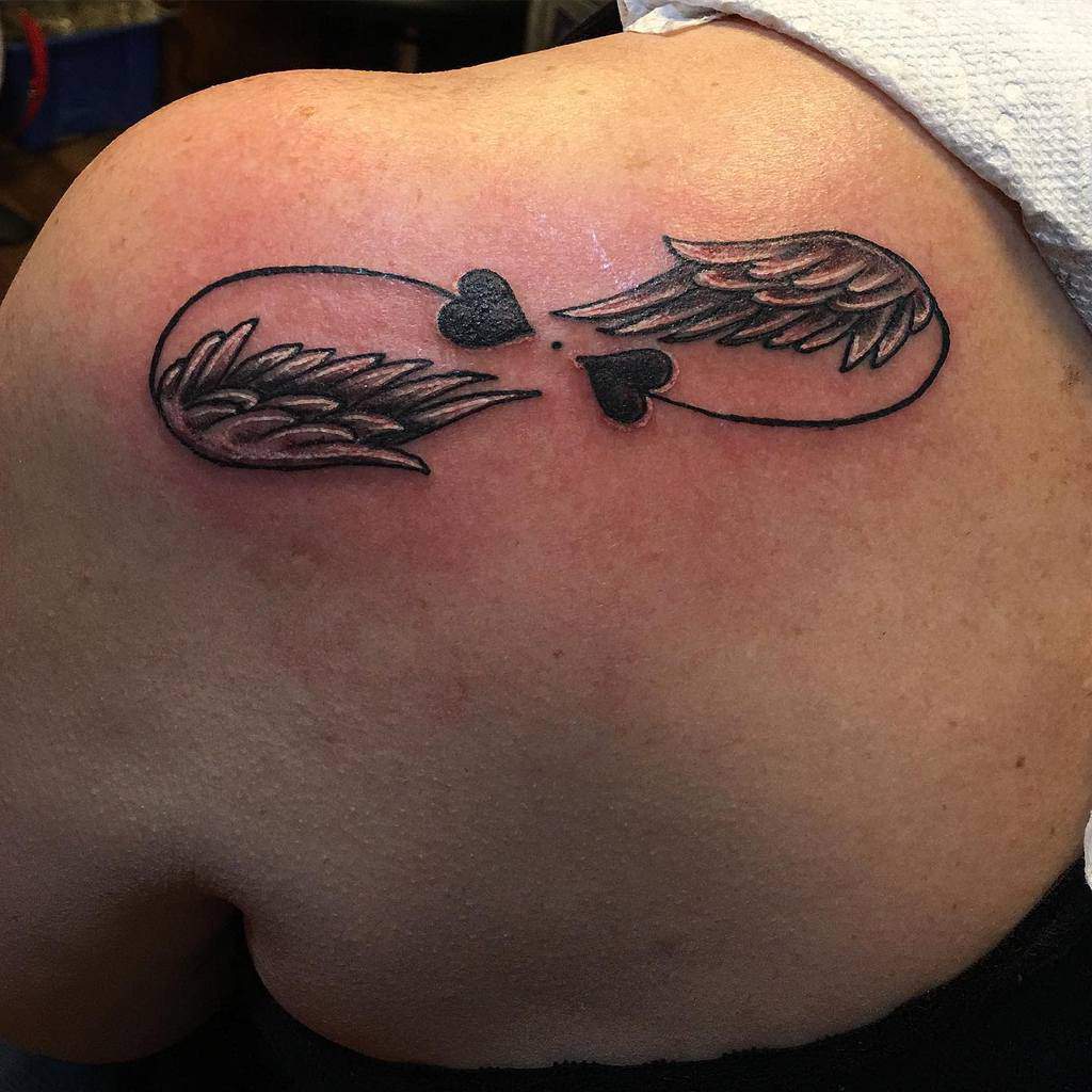 Tattoo of an infinity symbol with wings and a heart delicately
