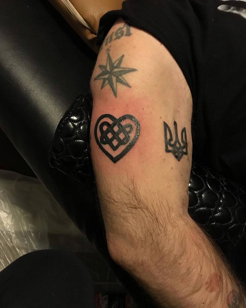 An upper arm with an infinity heart tattoo