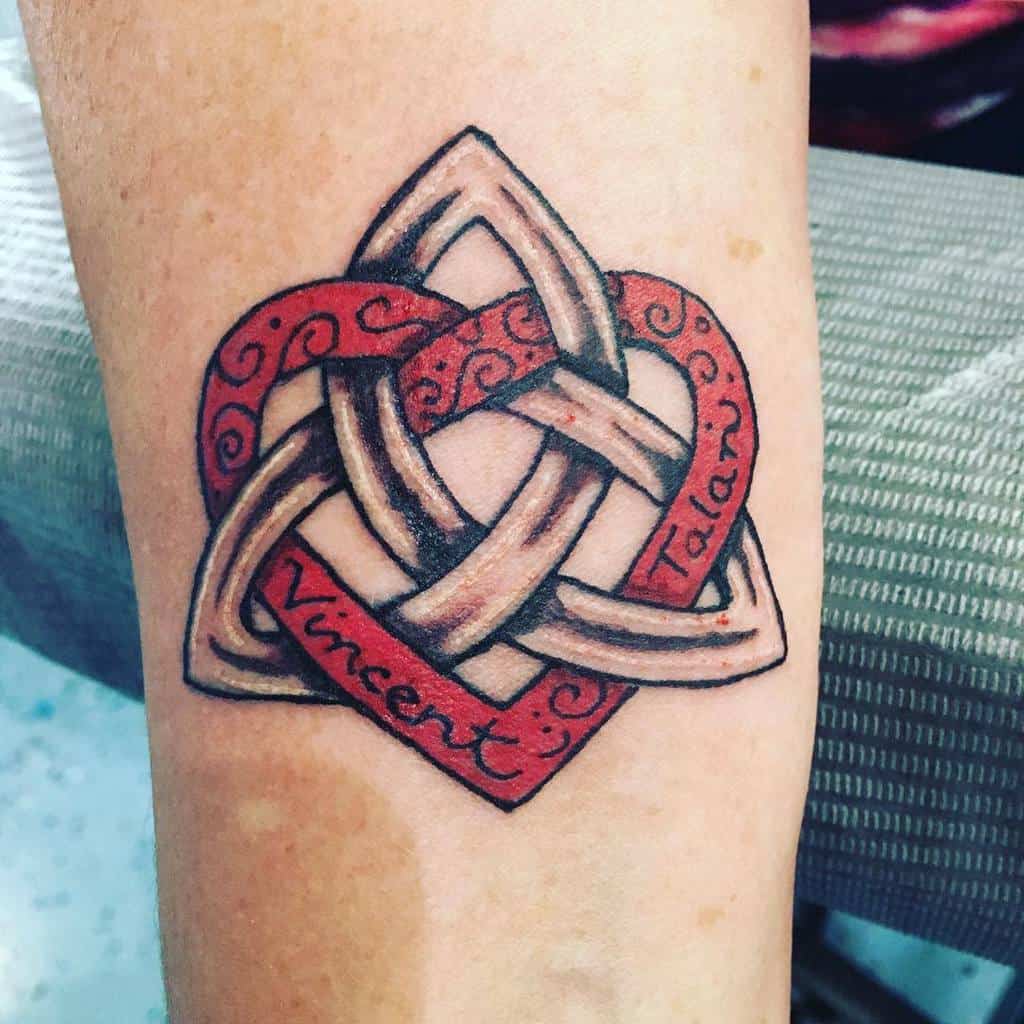 Celtic knot tattoo with red accents, featuring a heart and the names "Vincent" and "Tala," creating a sense of infinity