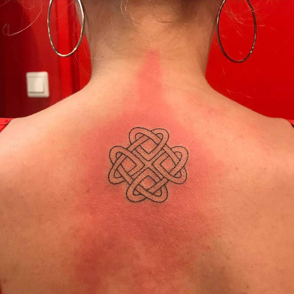 Geometric knot tattoo in the shape of an infinity symbol on the back