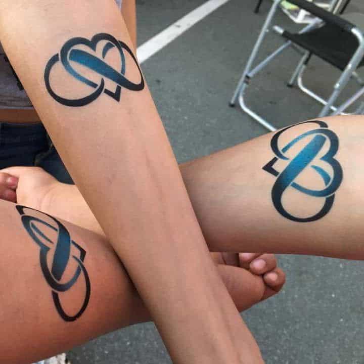 Matching tattoos of intertwined hearts with an infinity symbol in black and blue gradient ink on three people's arms