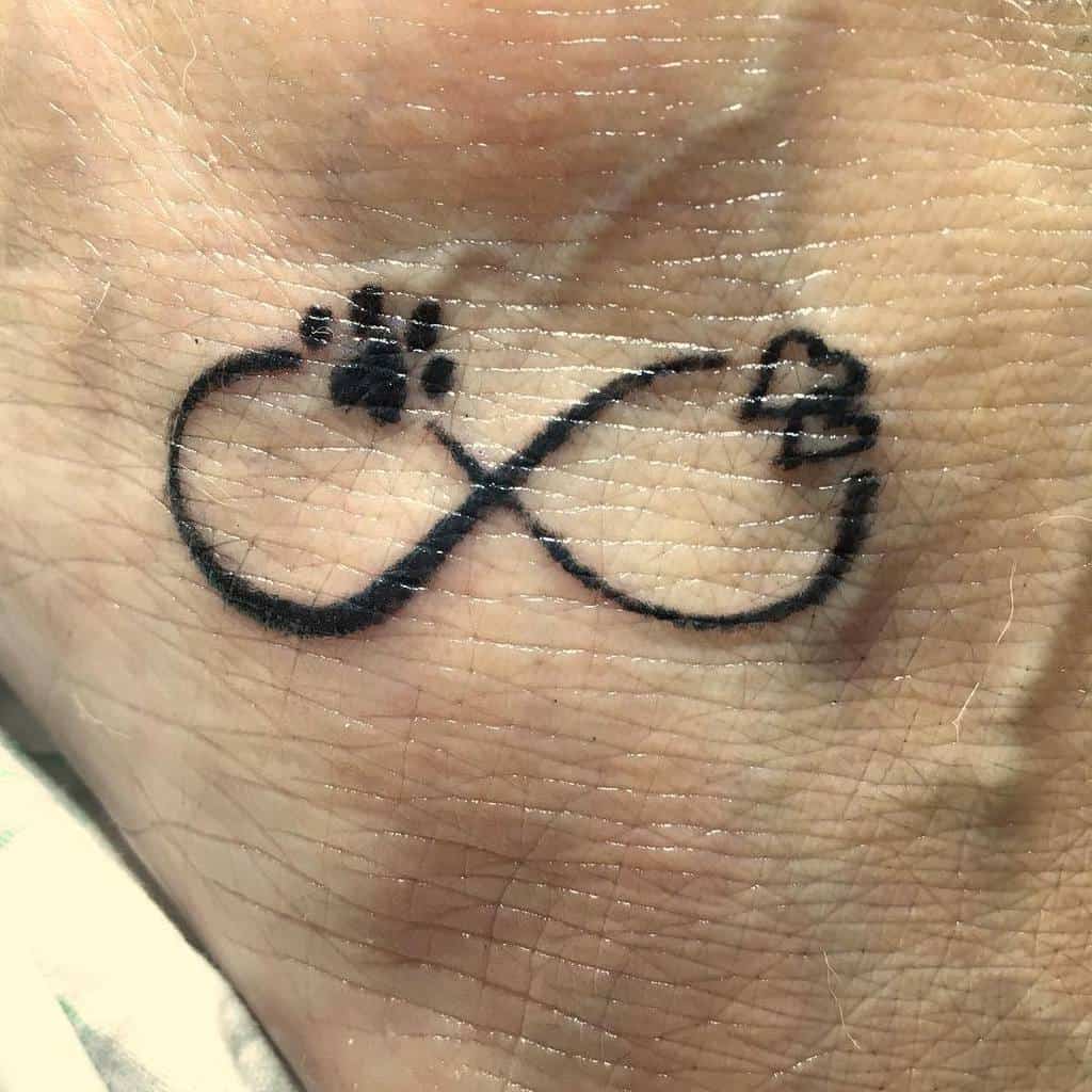 An infinity symbol tattoo gracefully adorns the skin, featuring a paw print and a heart at each end