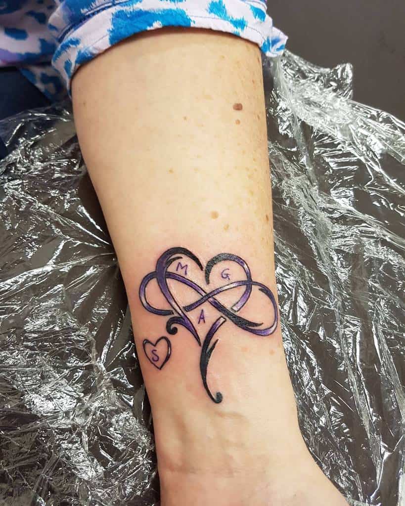 Heart tattoo on a wrist with intertwined infinity symbol, and initials "M", "G", "A", and "S" inside it