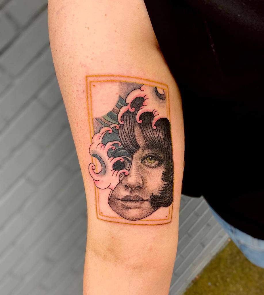 Tattoo of a woman's face with pink ocean waves and rectangular frame on an arm