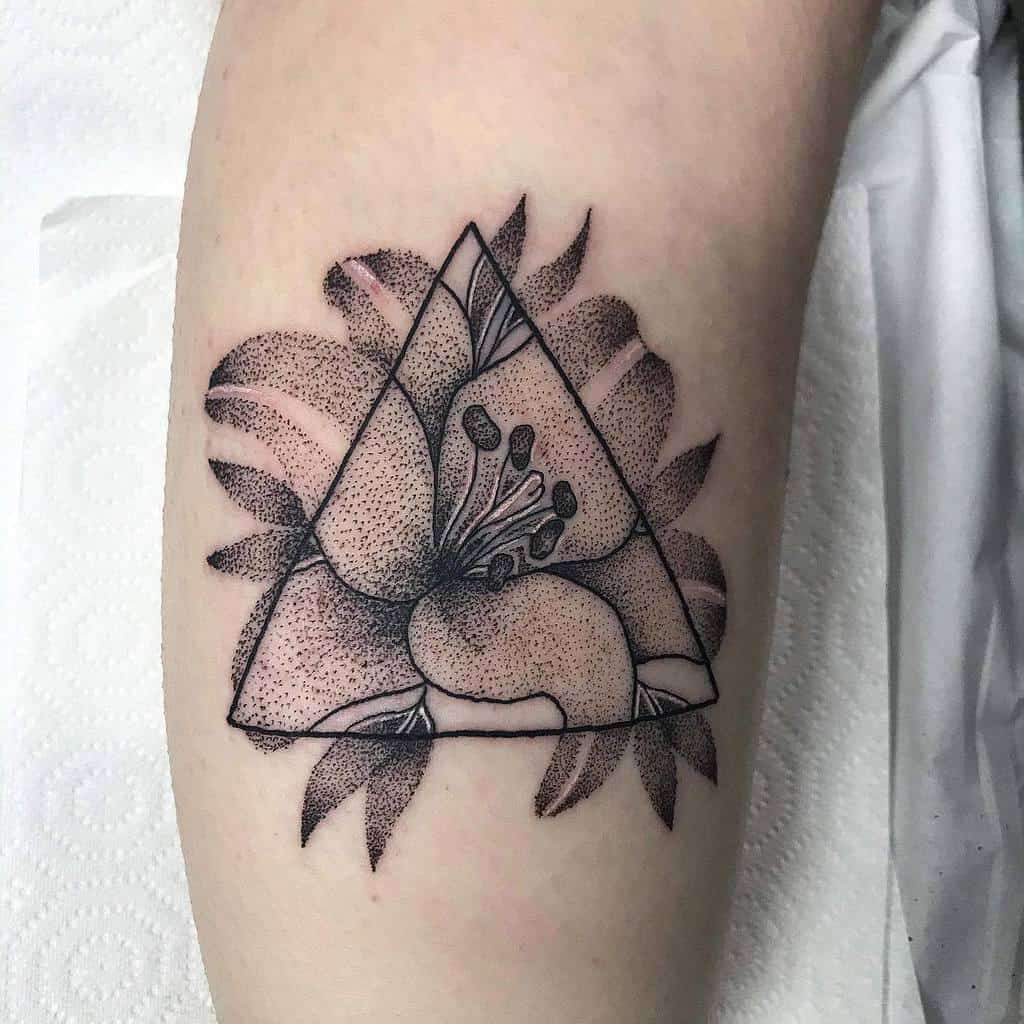 Unique black and grey tattoo of a lily inside a geometric triangle with intricate dot work