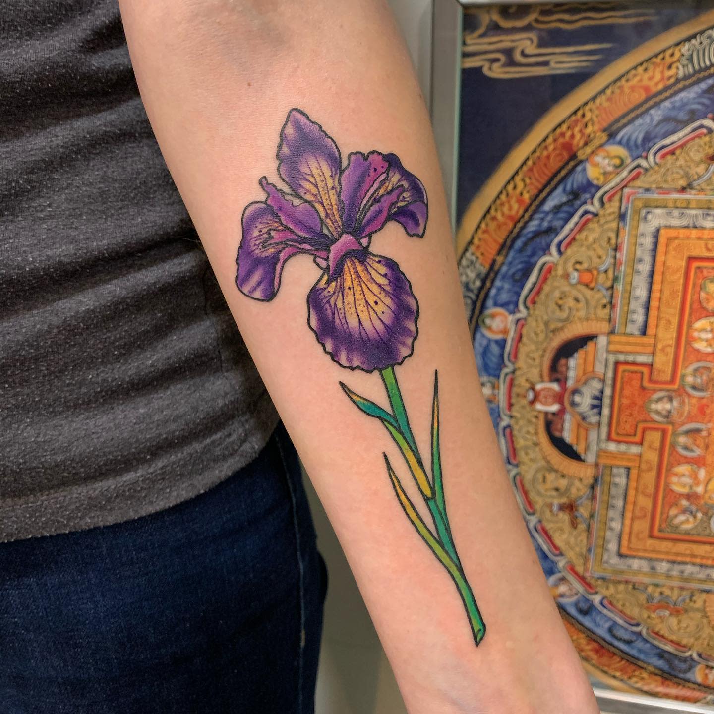 Forearm tattoo of a purple iris flower