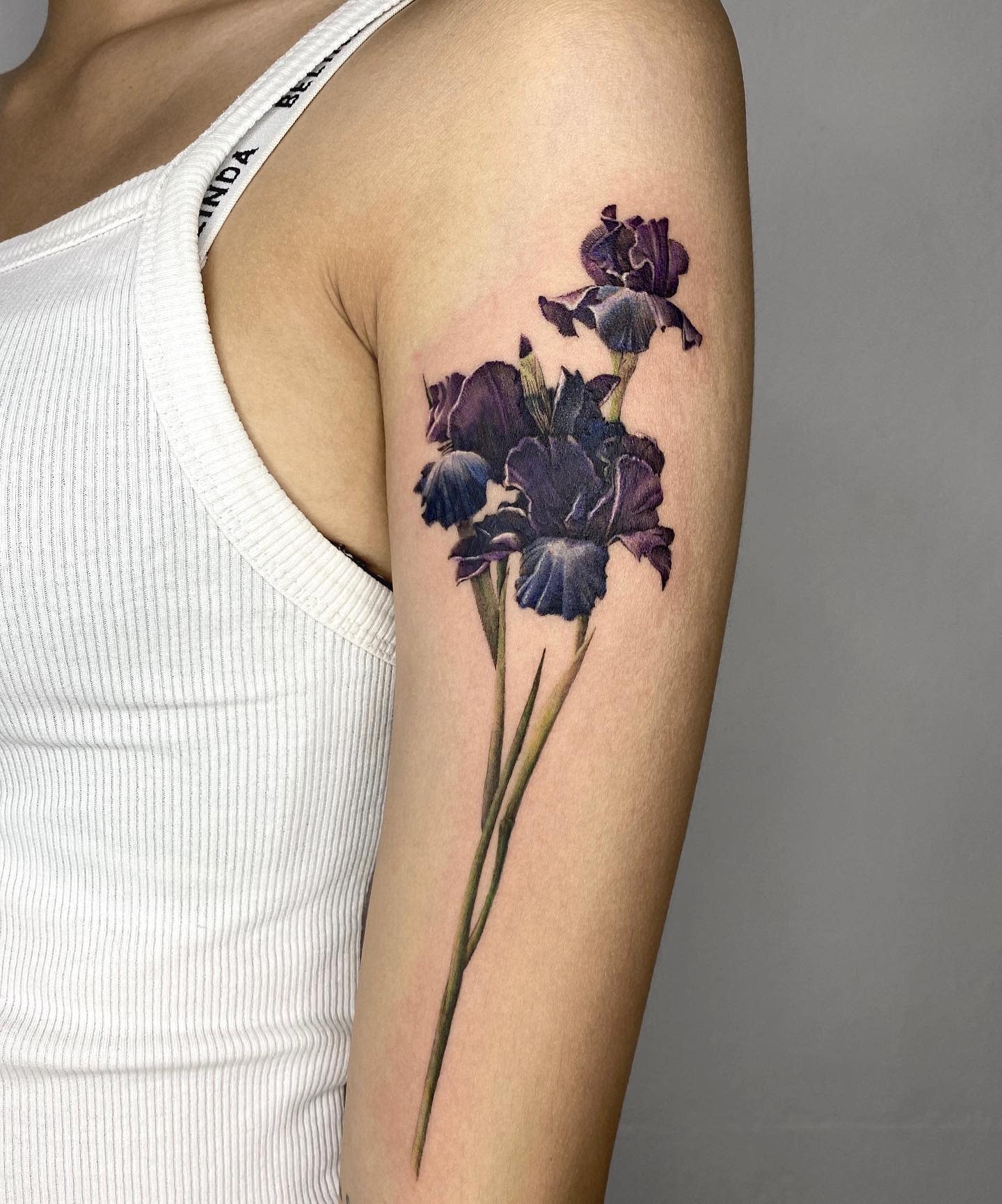 Arm tattoo of blue and purple iris flowers