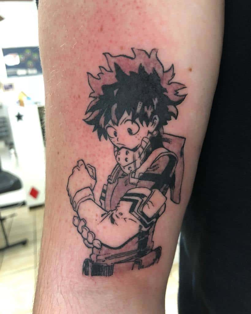 Black and grey tattoo of Izuku Midoriya from My Hero Academia, showing him in his hero costume with a determined look, adjusting his gloves