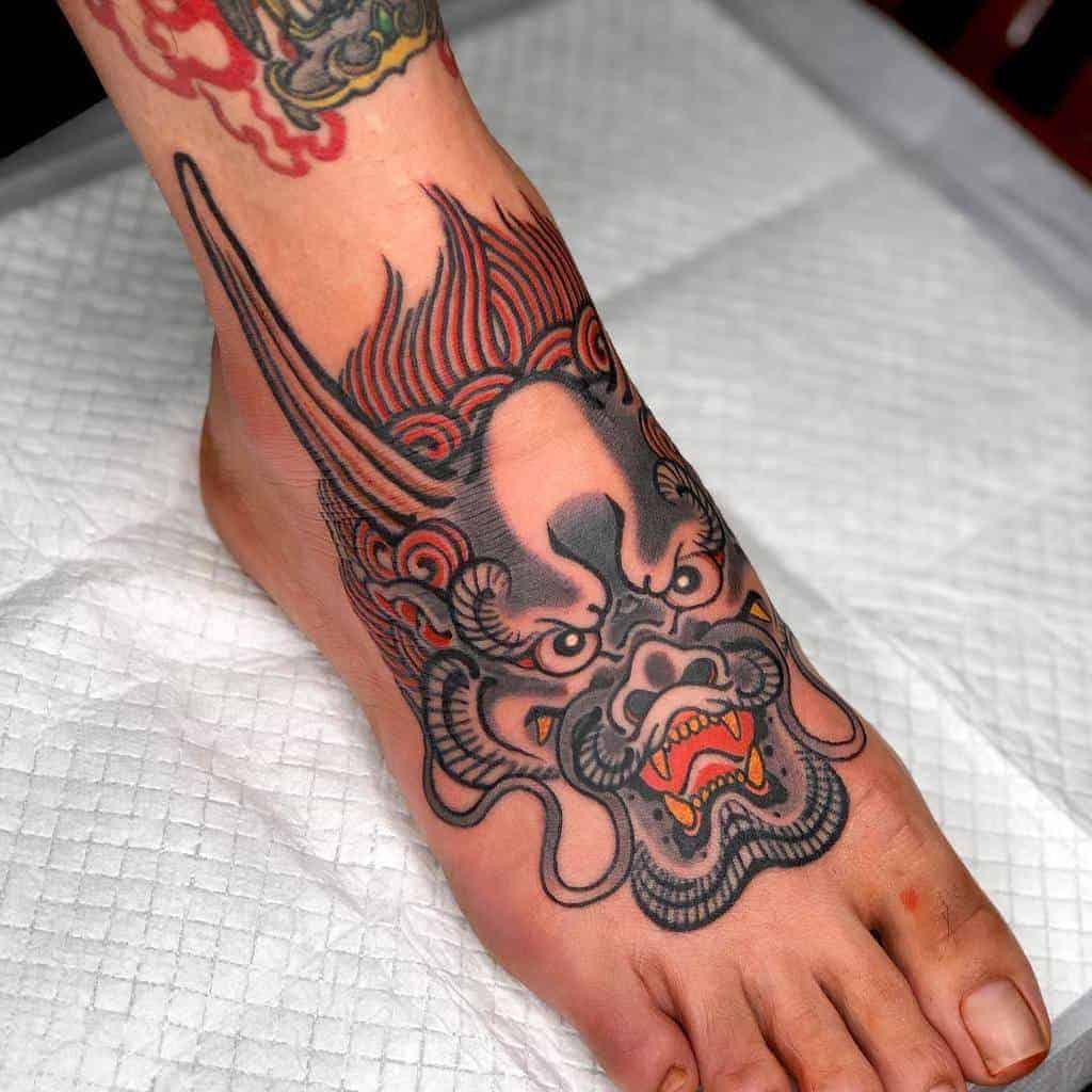 Foot tattoo showcasing a fierce, colorful dragon on the top