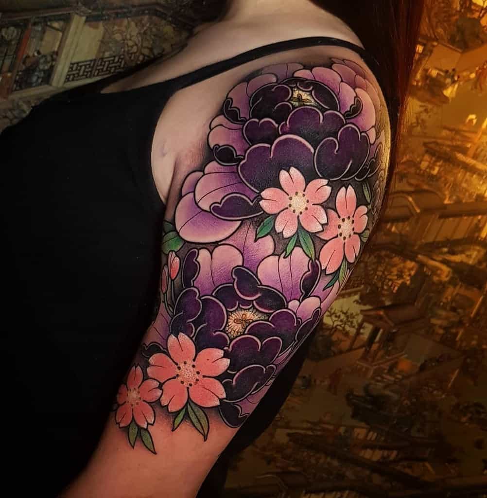 Woman with colorful floral tattoo sleeve on upper arm