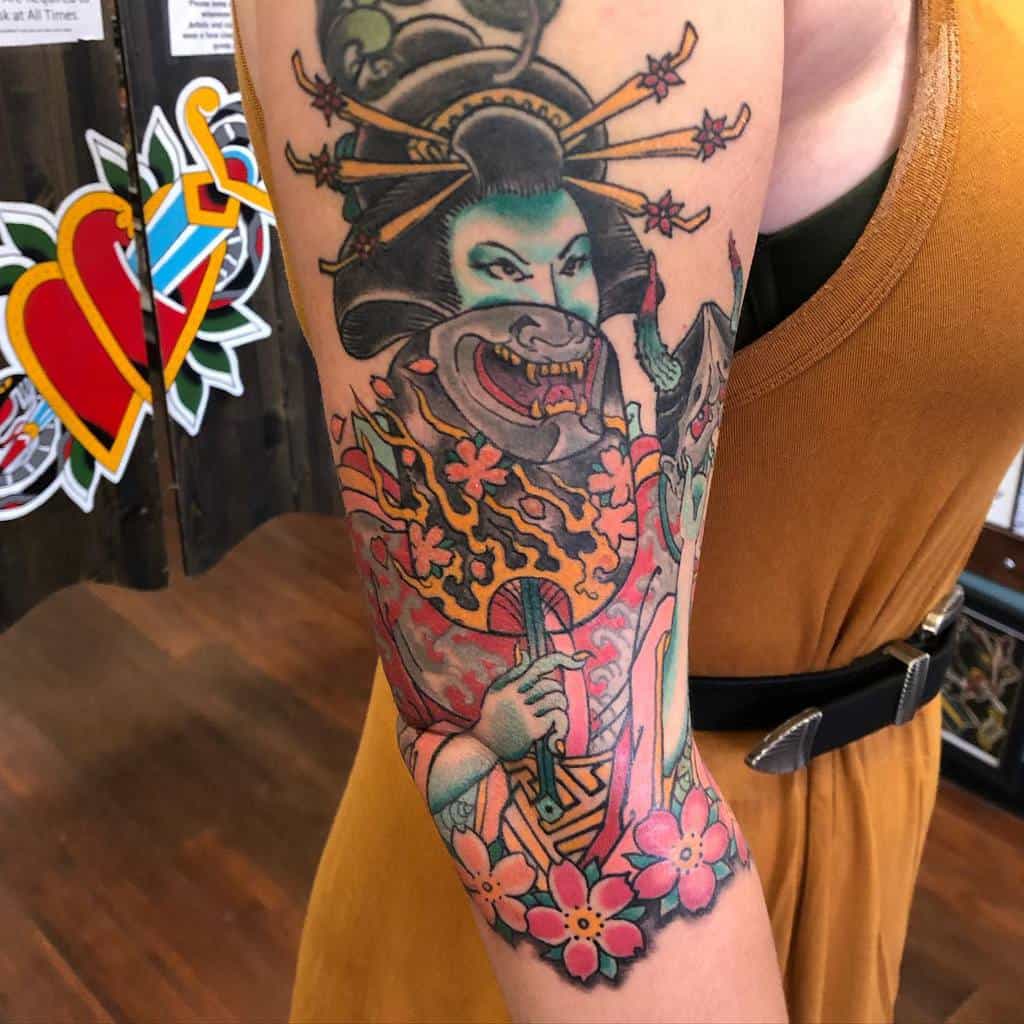 Colorful arm tattoo of a Japanese-inspired figure with floral details