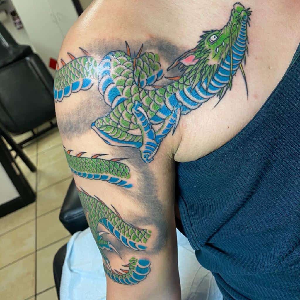 A colorful dragon tattoo wraps around a woman's upper arm and shoulder