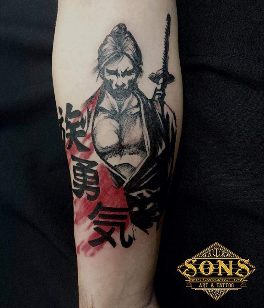 Tattoo of a samurai with kanji symbols and a red background on an arm