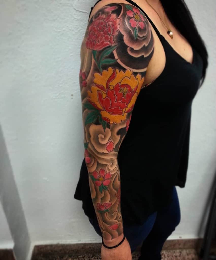 Woman with a floral sleeve tattoo in colorful hues