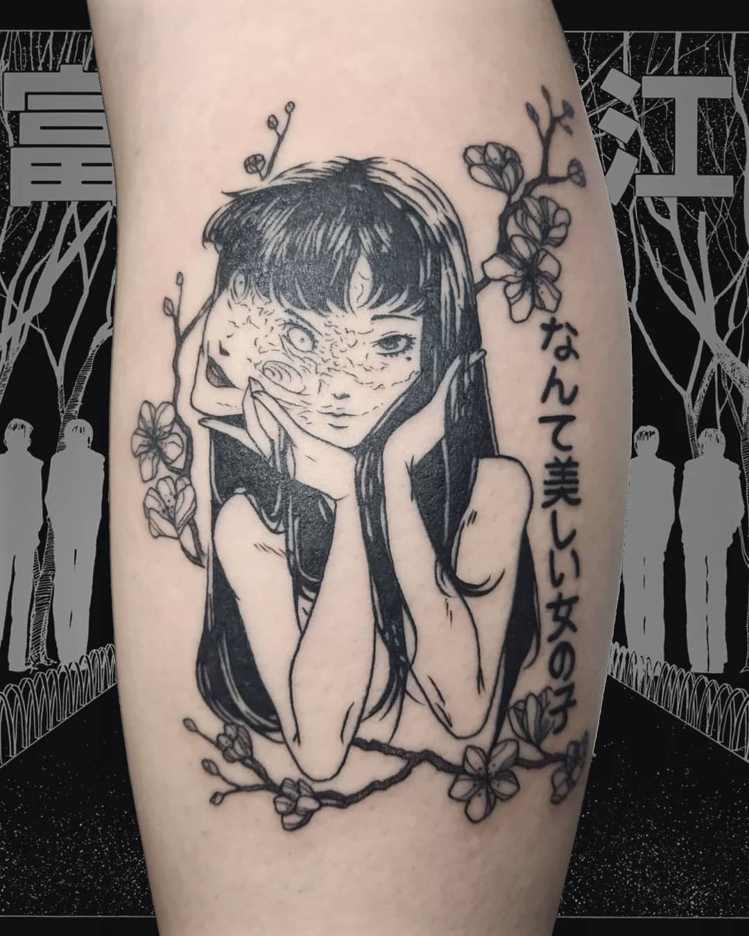 Leg tattoo of a Junji Ito character with a distorted face, framed by flowers and Japanese text